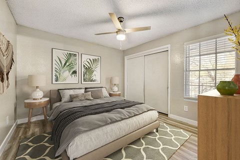 A bedroom with a bed, nightstands, and a ceiling fan.