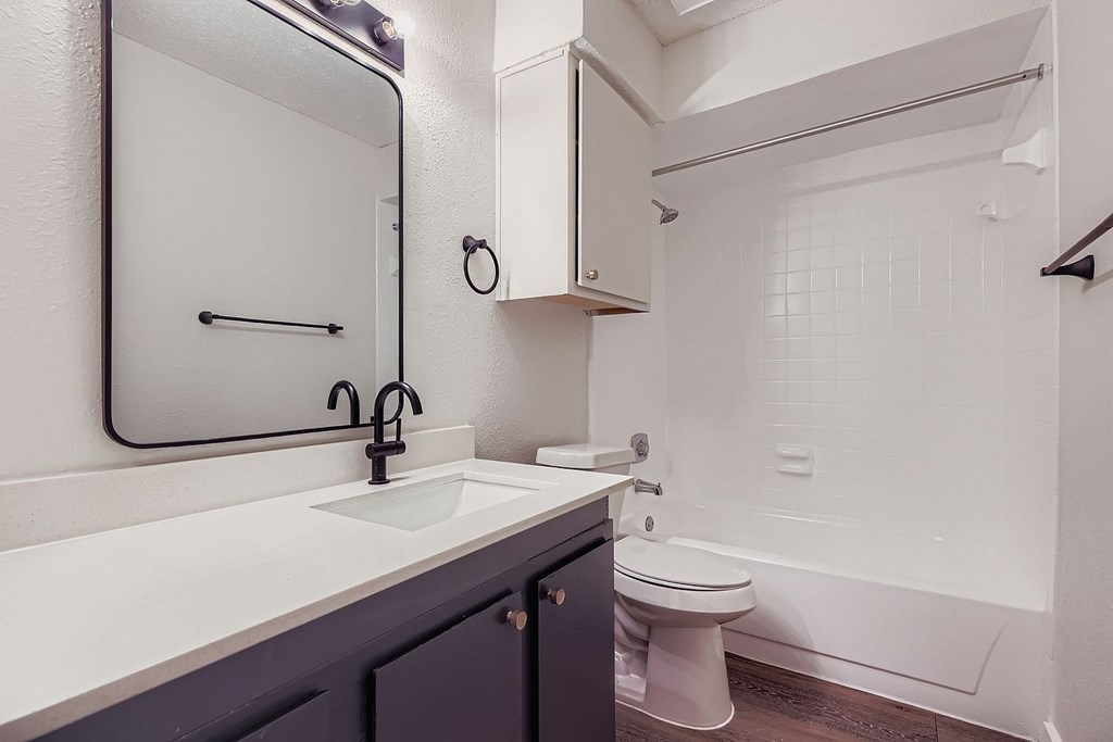 A bathroom with a white sink and a white toilet.