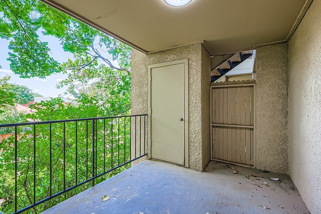 A balcony with a black railing and a white door.