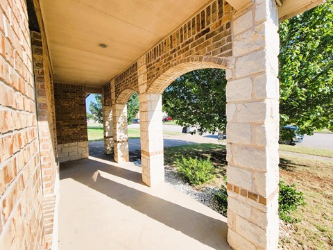 A long corridor with arches and a grassy area on the side.