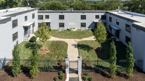A courtyard surrounded by buildings with a black fence.