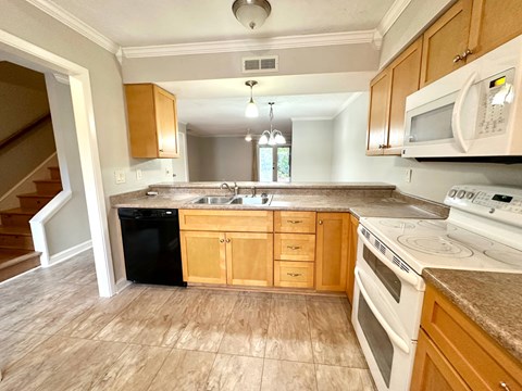 A kitchen with wooden cabinets and white appliances.