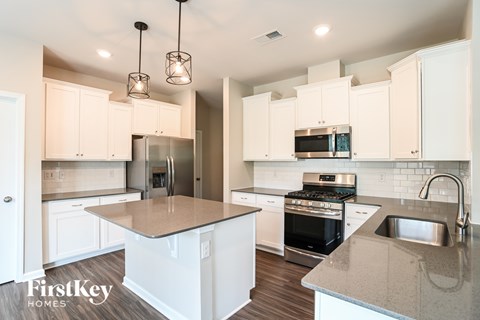 A kitchen with a stove top oven and a microwave above the stove.