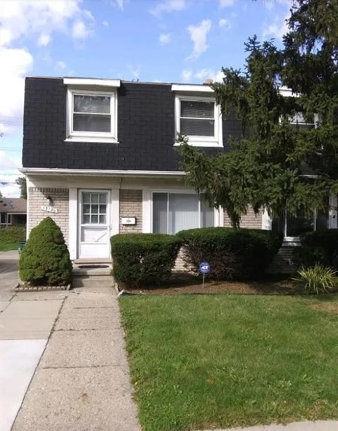 A house with a white door and a small front yard.