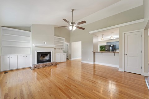 A living room with a fireplace and a ceiling fan.