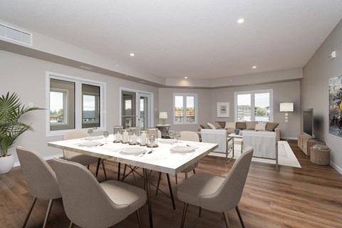 A dining room with a table set for six with chairs around it.