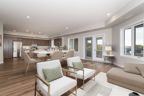 A modern living room with a dining area in the background.