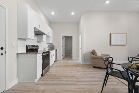 A kitchen with a dining table and chairs in the living room.