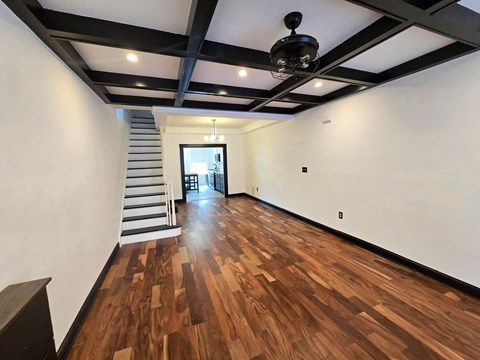 A room with wooden floors and a staircase.