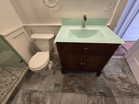 A white toilet sits next to a sink in a bathroom.