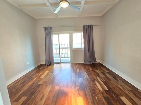 A room with wooden floors and a ceiling fan.