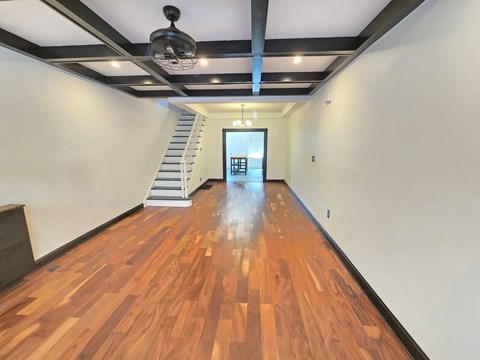 A long hallway with a staircase and a light on the ceiling.