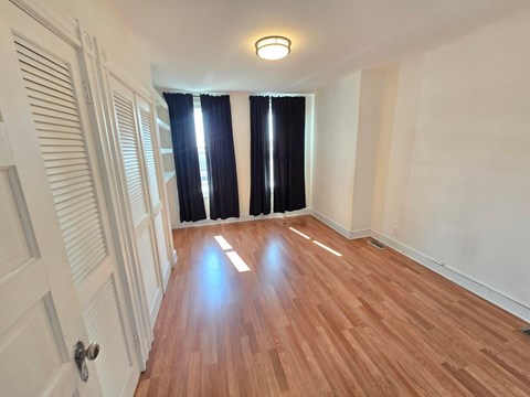 A room with wooden flooring and a white door.