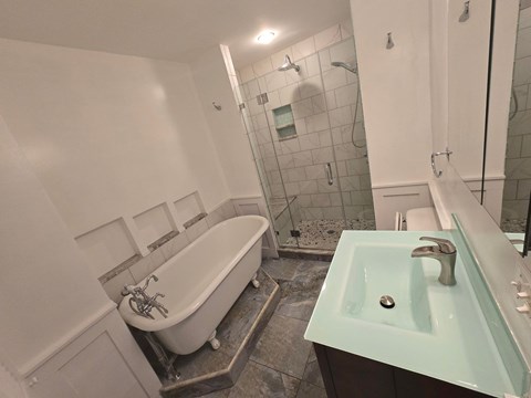 A white bathroom with a white tub and a sink.