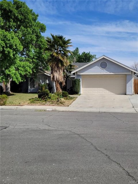 A house with a garage and a driveway in front of it.