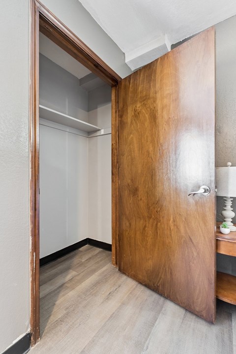 A wooden door is open to a hallway.