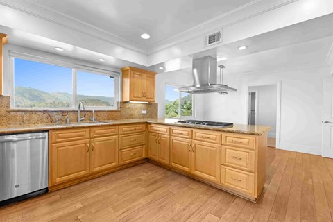 A kitchen with wooden cabinets and a stainless steel range hood.