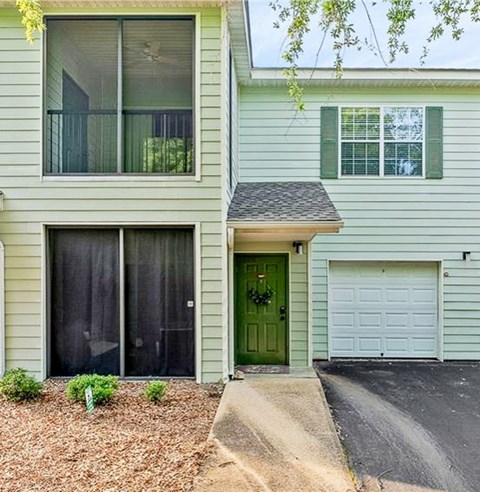 A house with a green door and a garage door.