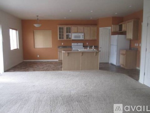 A kitchen with orange walls and white appliances is available for rent.