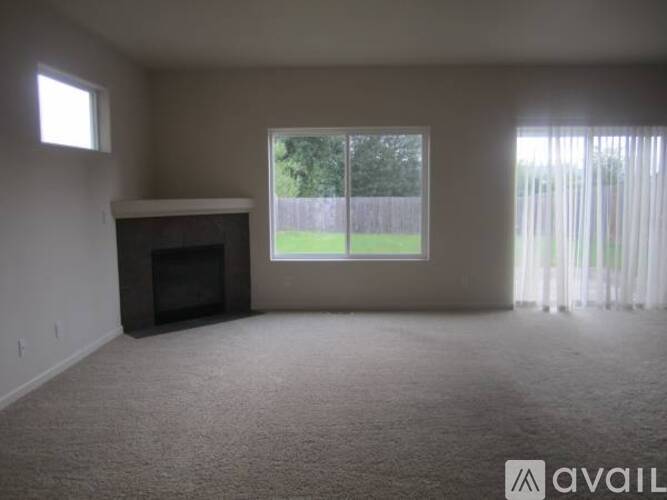 A living room with a fireplace and a large window.