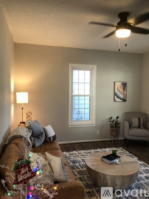 A living room with a couch, a coffee table, and a ceiling fan.