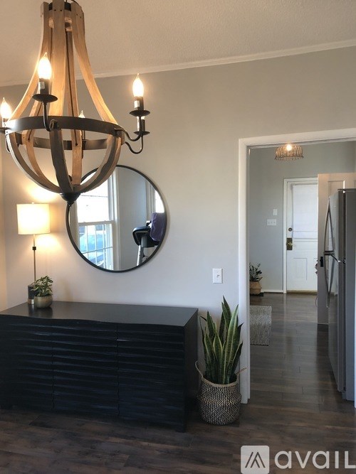 A chandelier hangs over a black reception desk in a well-lit room.