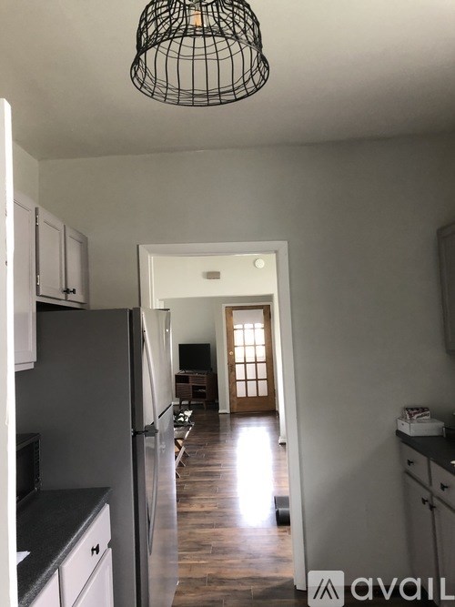 A kitchen with a black fridge and a black counter top.