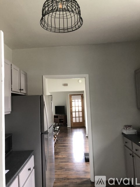 A kitchen with a black fridge and a black counter top.