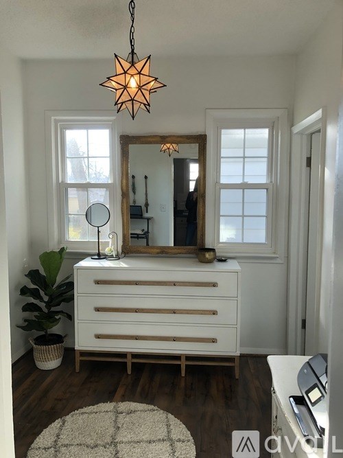 A white dresser with a mirror and a star-shaped light hanging above it.