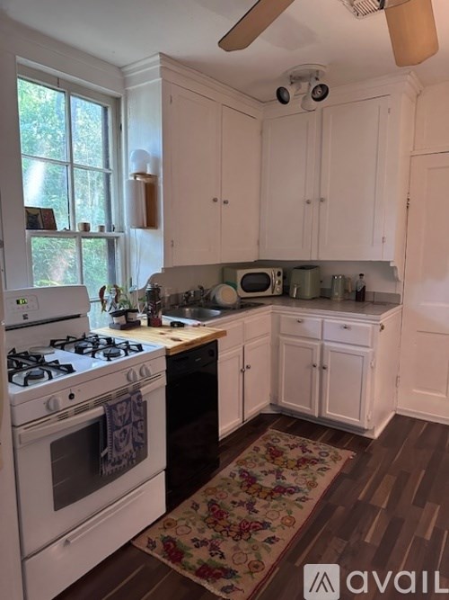 A kitchen with white cabinets and a black stove top.
