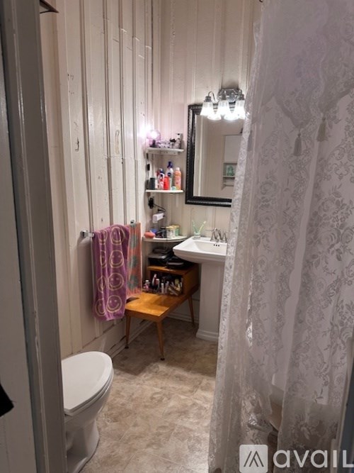 A bathroom with a toilet, sink, and a mirror.