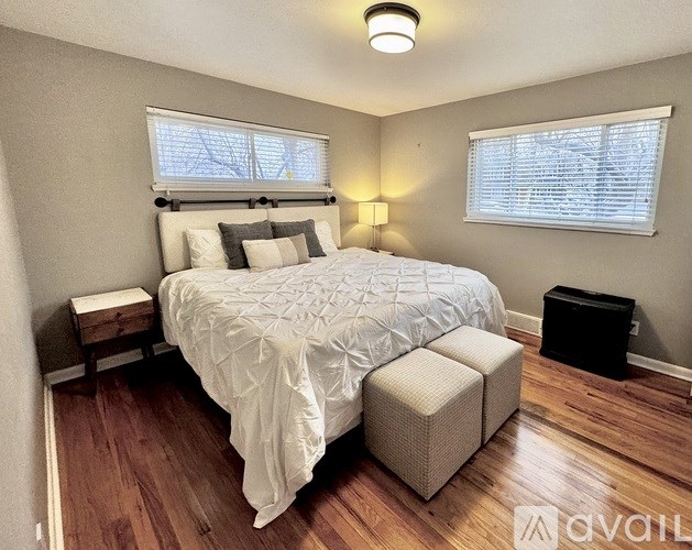 A bedroom with a bed, nightstand, and window.