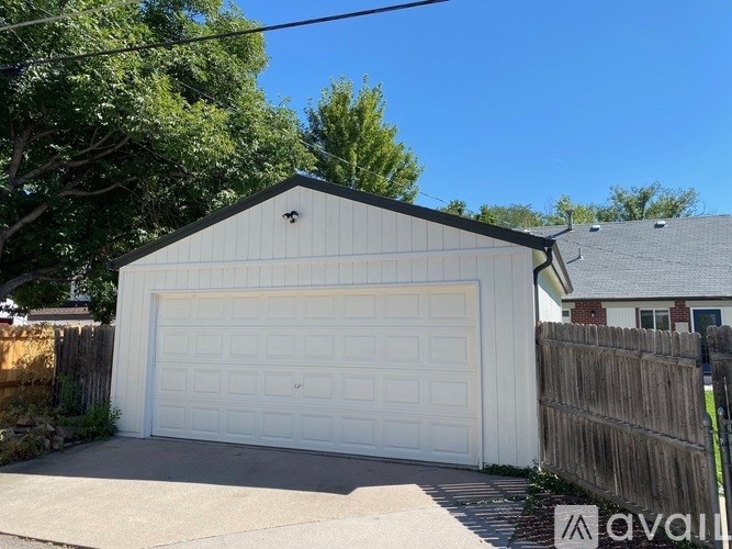 A white garage door is closed and the garage is attached to a house.