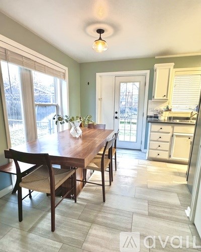 A dining room with a table and chairs.
