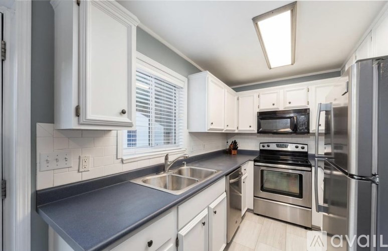 A kitchen with white cabinets and stainless steel appliances.