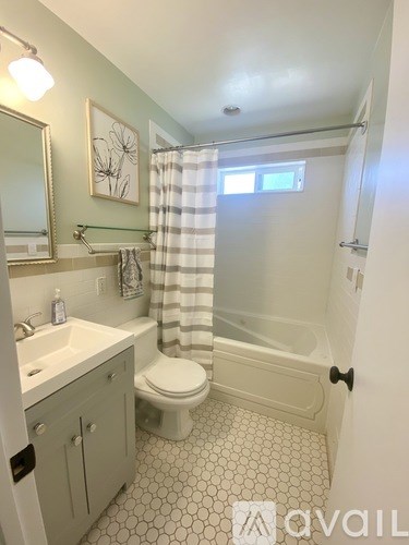 A bathroom with a toilet, sink, and shower.