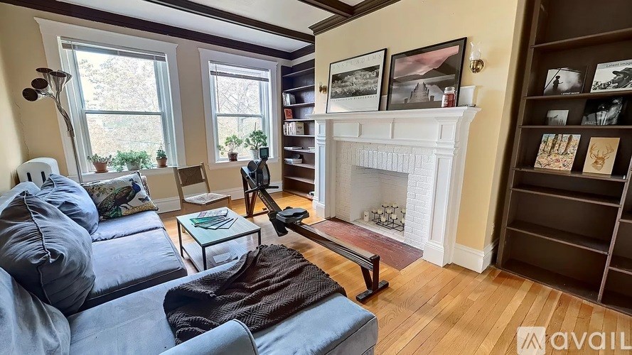 A living room with a blue couch and a fireplace.