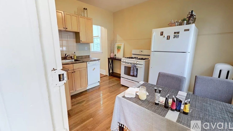 A kitchen with a white fridge and a table with drinks on it.