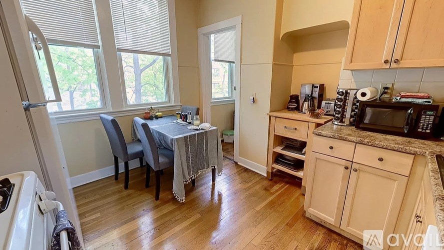 A kitchen with wooden floors and a dining table with chairs.