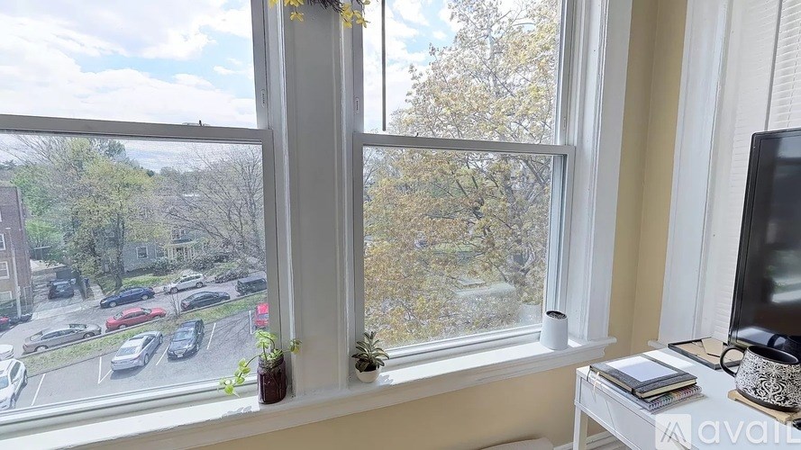 A room with a window overlooking a parking lot.