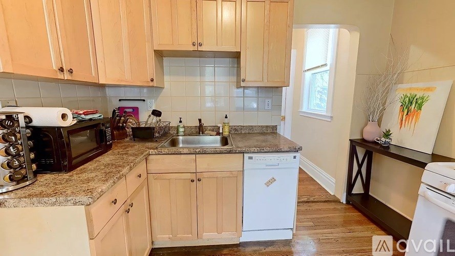 A kitchen with wooden cabinets and a white dishwasher.