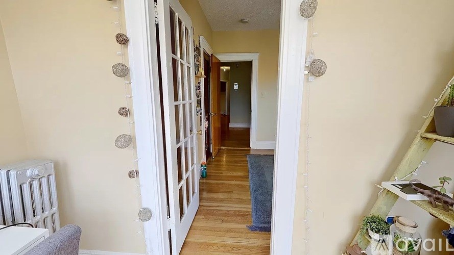 A hallway with a white door and a grey carpet.