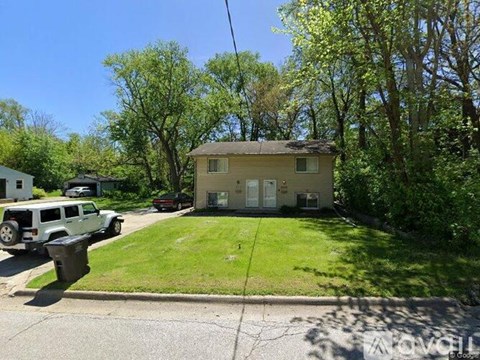A house with a white car and a white jeep parked in front.