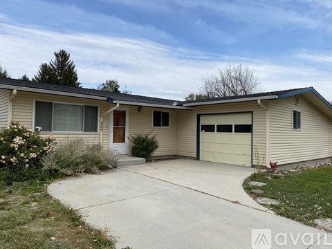 A beige house with a brown door and a white garage door.