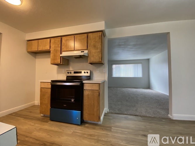 A kitchen area with wooden cabinets and a black oven.