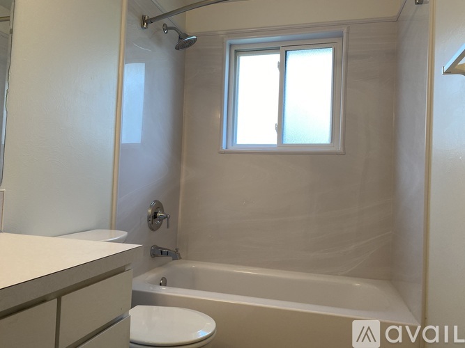 A bathroom with a tub, toilet, and sink.