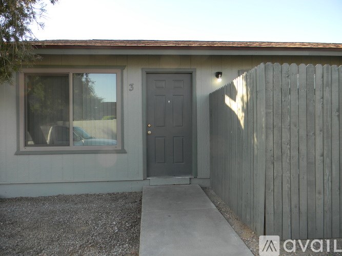 A house with a grey door and a grey fence.