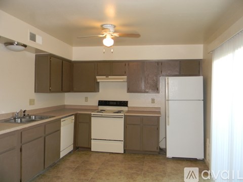 A kitchen with white appliances and brown cabinets.