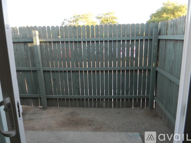 A wooden fence with a gate in front of it.