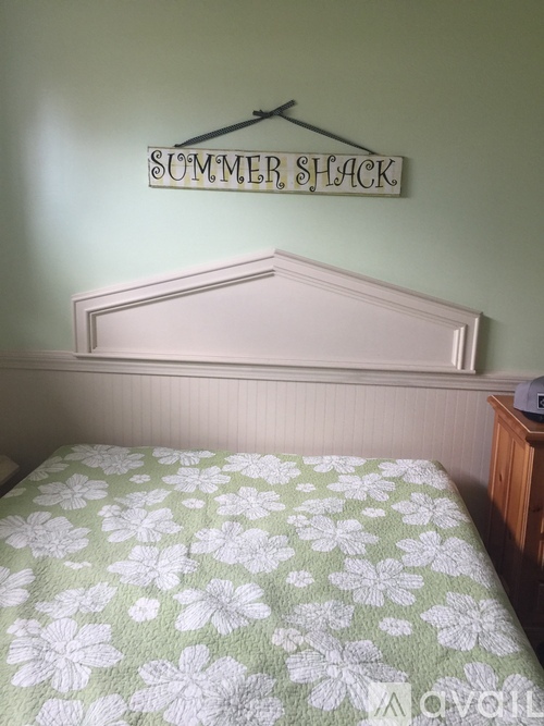 A bedroom with a bed and a sign that says "Summer Shack".